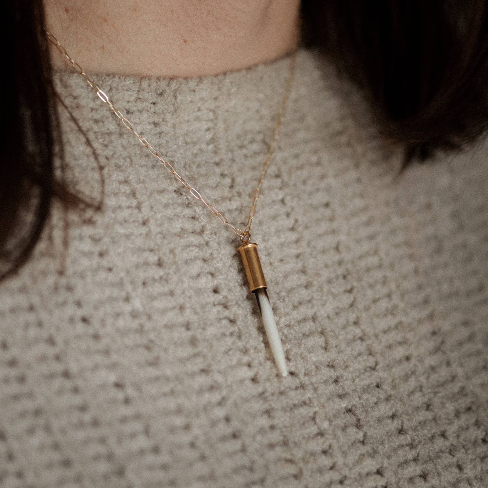 Necklace with a unique pendant worn by a person against a neutral background