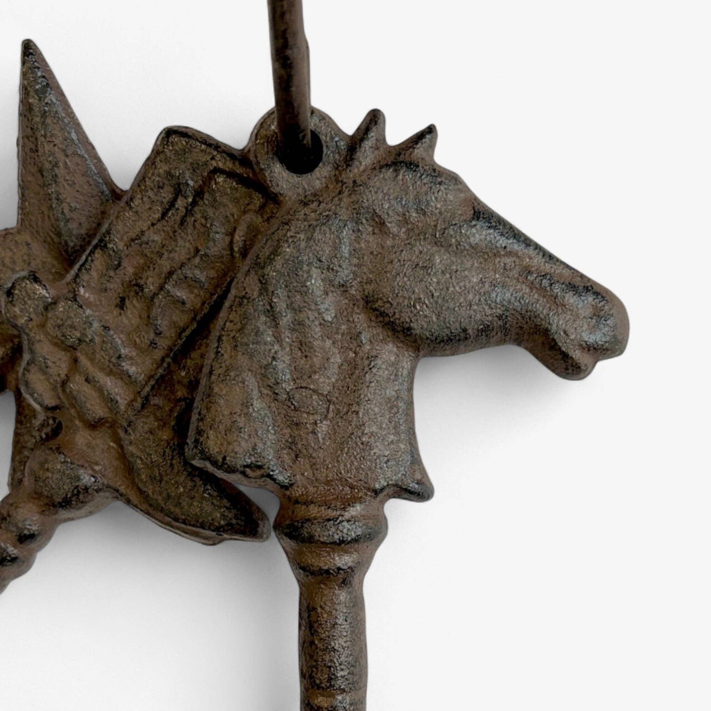 Decorative metal wall hook shaped like a horse head on a white background