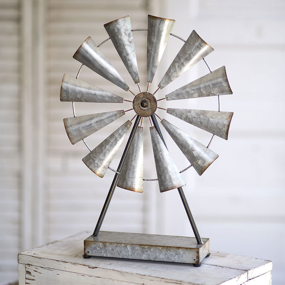 This classic farmhouse tabletop windmill is crafted from durable metal. This vintage-inspired accent piece is designed to add charm and character to any room in your home. The wheel spins effortlessly, adding movement and interest to your décor. Whether placed on a mantel, bookshelf, or coffee table, this windmill is sure to captivate your guests and become a beloved piece in your collection. 