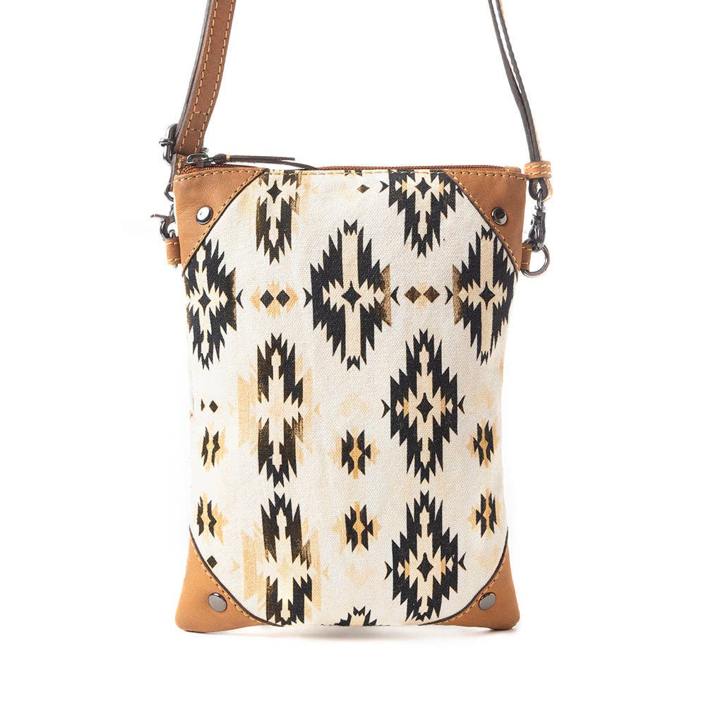 Crossbody bag with tribal pattern and brown leather accents on a white background