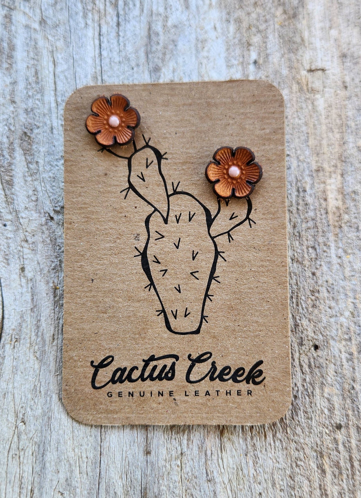 Pair of leather earrings shaped like cacti on a Cactus Creek branded card.