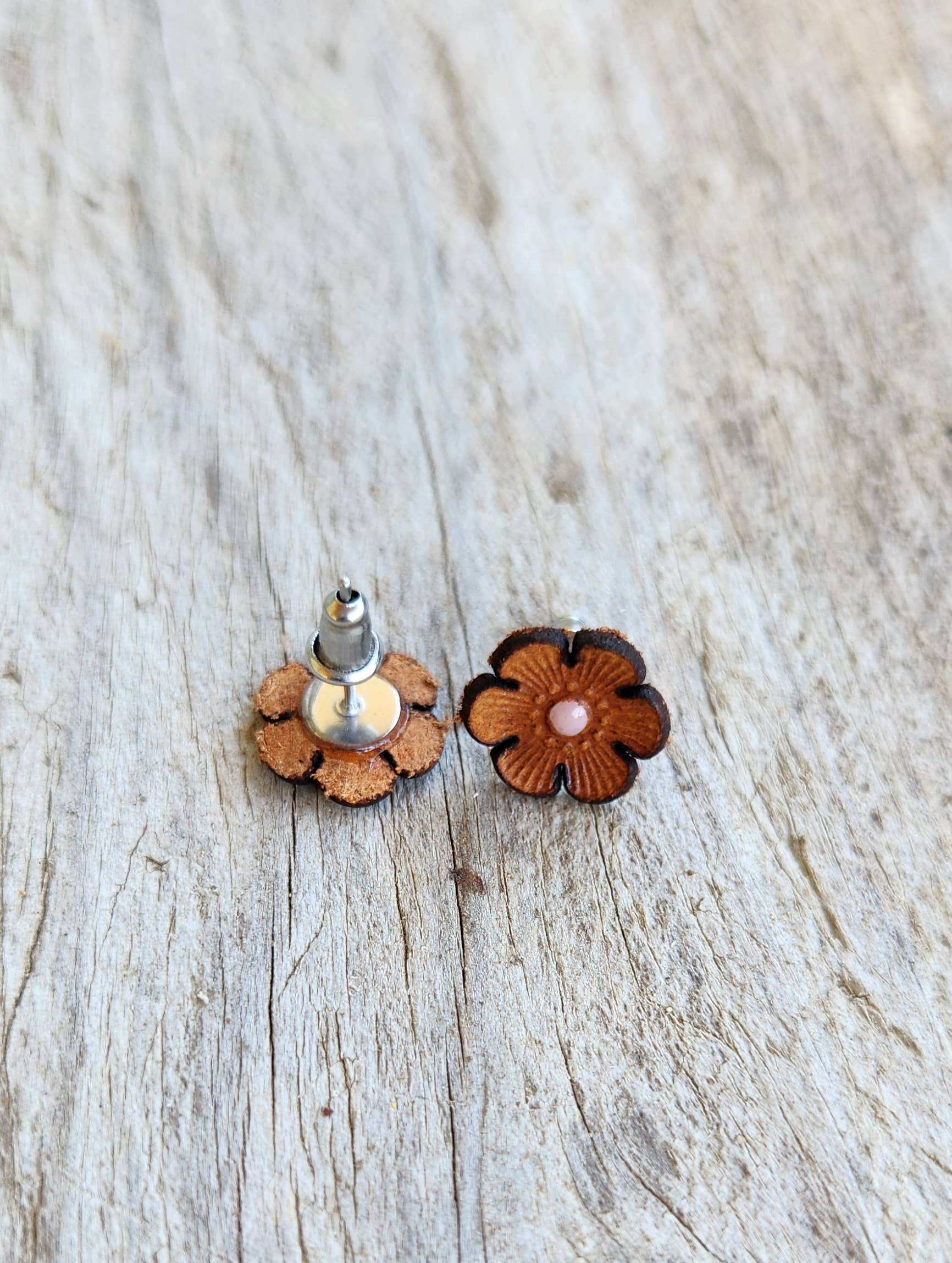 Flower-shaped earrings on a wooden surface