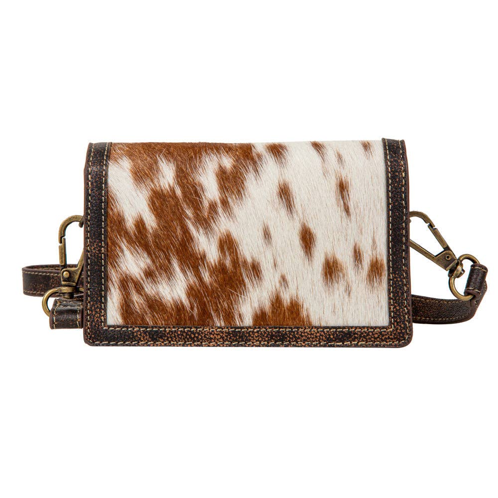 Small leather bag with cowhide pattern on a white background