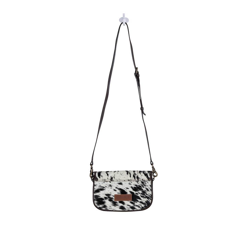 Crossbody bag with cow print pattern on a white background