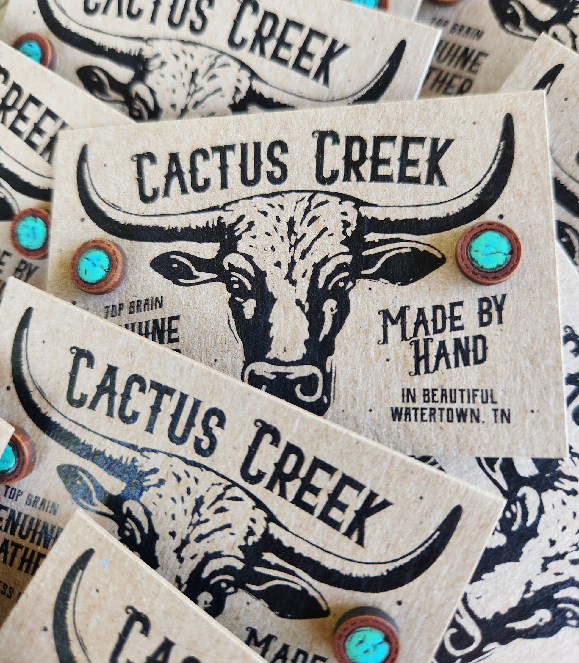 Stack of Cactus Creek branded product labels with a bull illustration.