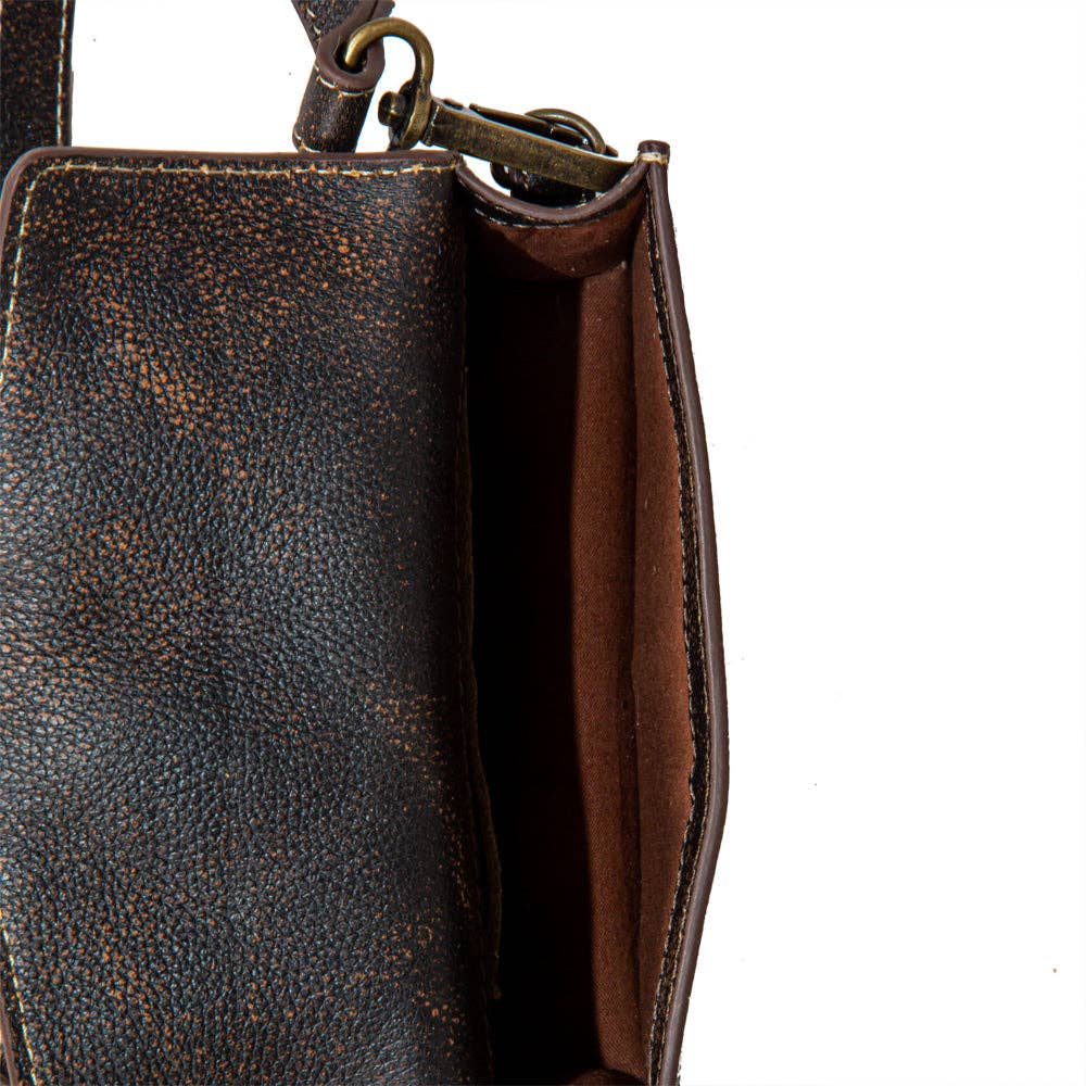 Close-up of a brown leather handbag with a textured surface on a white background