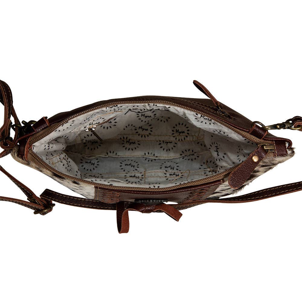 Brown leather handbag with floral interior lining on a white background