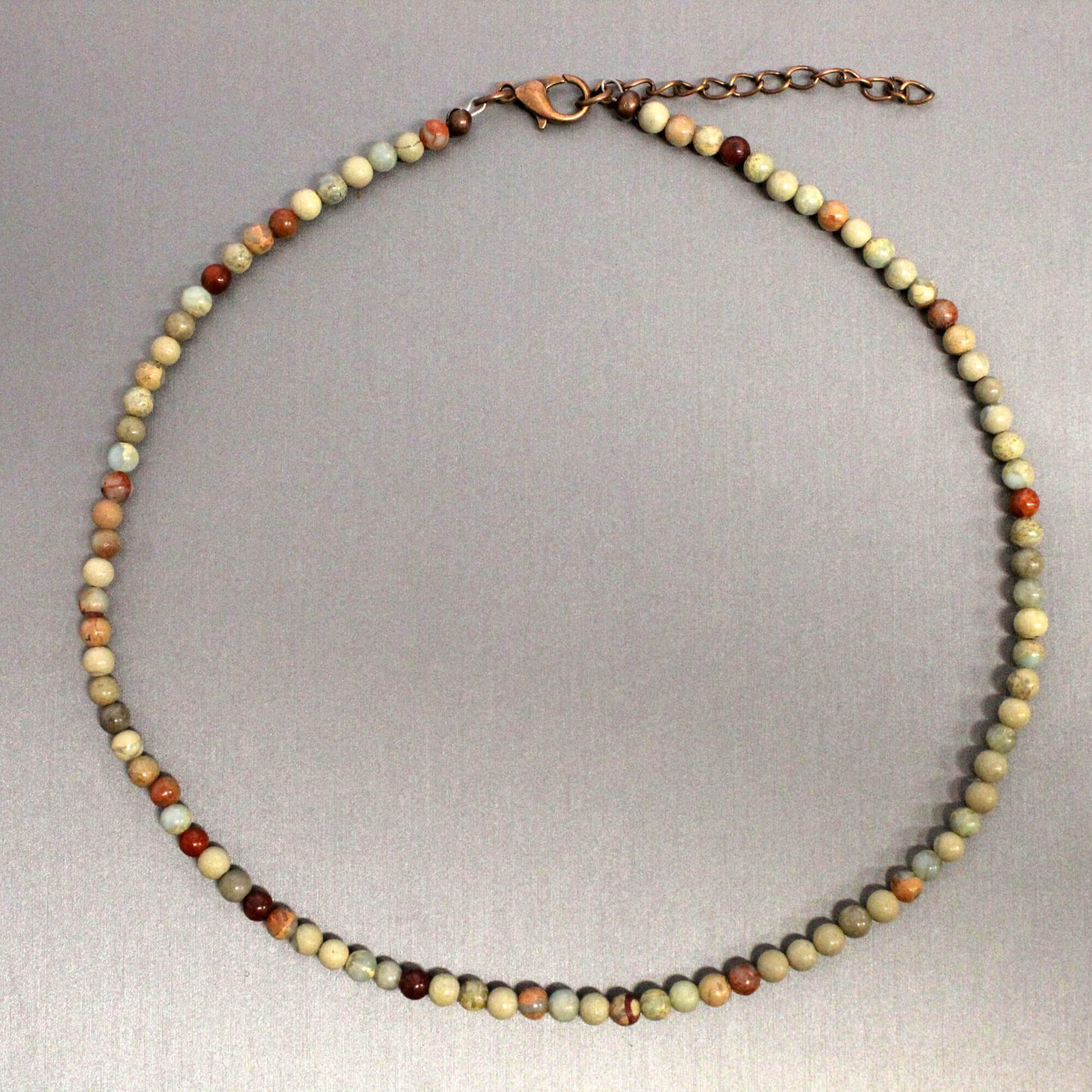 Necklace with multicolored beads on a gray background