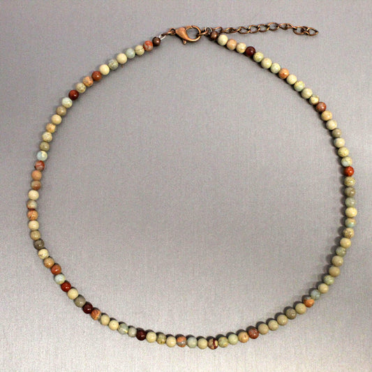 Necklace with multicolored beads on a gray background