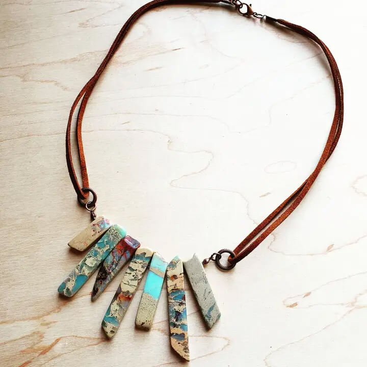 Beautiful genuine aqua terra stones make up this adjustable necklace on genuine leather cord. Adjusts from 18" to 24" by simply pulling the leather cords. Great for layering or as a statement piece. Made in USA