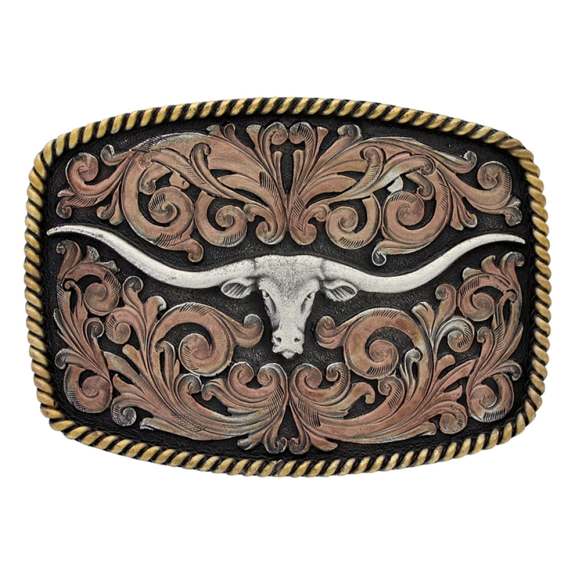 An antiqued western belt buckle with a center silver tone elongated longhorn figure with rose gold toned filigree and yellow gold toned rope edging. Western Buckle measures 3-1/2 X 2-3/4