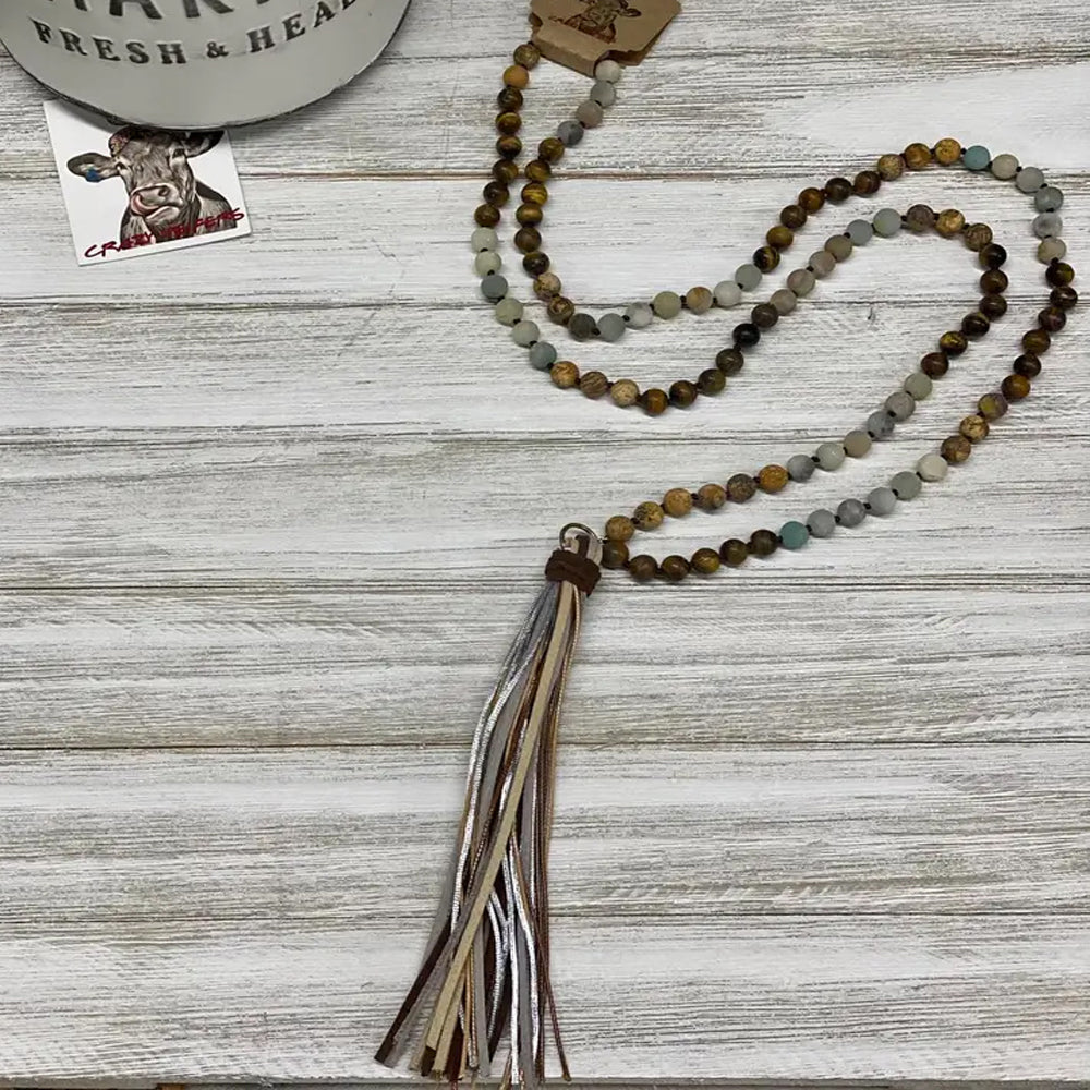 Embrace your bohemian spirit with our Boho Tribal Long Tassel Necklace. The unique and intricate design captures the essence of tribal artistry, making it a perfect accessory for your boho-chic outfits. No two of these necklaces are exactly alike, adding to their unique charm. Whether you're dressing up for a special event or simply adding a touch of elegance to your everyday wear, this necklace is sure to make a statement. Agate beads & leather tassel. Made in Paraguay.