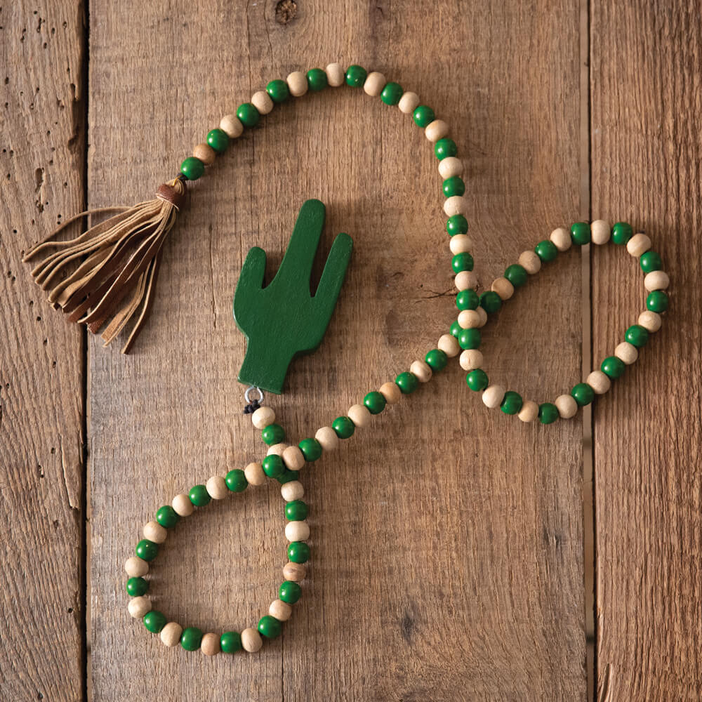 Use these beads to add texture and western charm to your two-tier trays, walls, or any way you can imagine! Each strand has wood beads with a leather tassel and cactus on the ends. Measurement: 49''W x 2''H