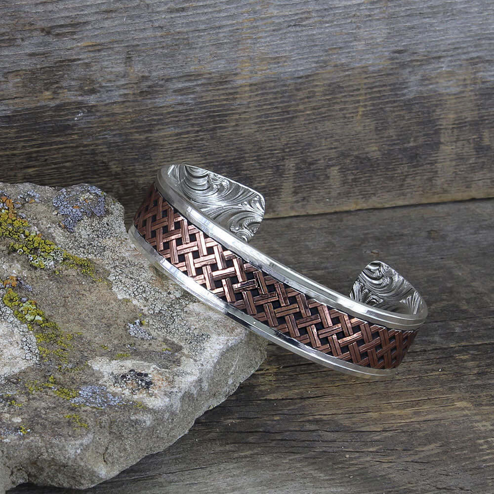 Classic Copper Weave Crossing Cuff Bracelet displayed on a textured stone surface.