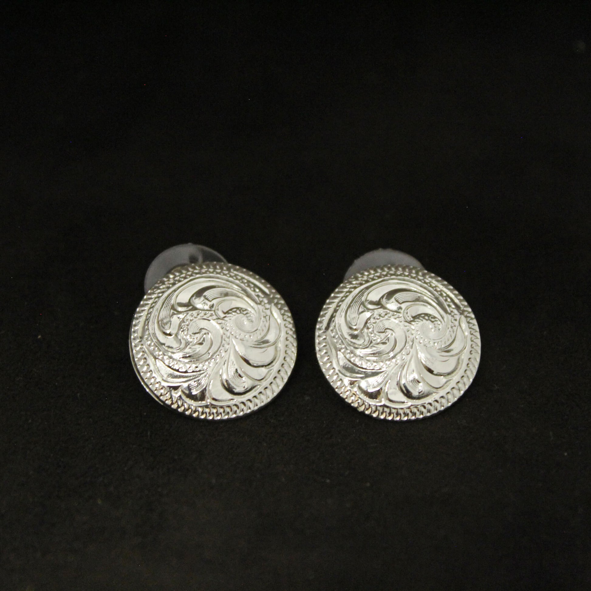 A classic Concho earrings for the classic cowgirl look. Western Buckarette earrings make a great gift for any western lady or buy for yourself and for that easy go-to pair. German silver engraved in a 3/4" diameter stud earrings.