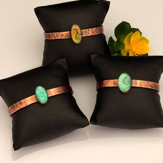 Three black jewelry pillows with copper and turquoise accents on a white background.