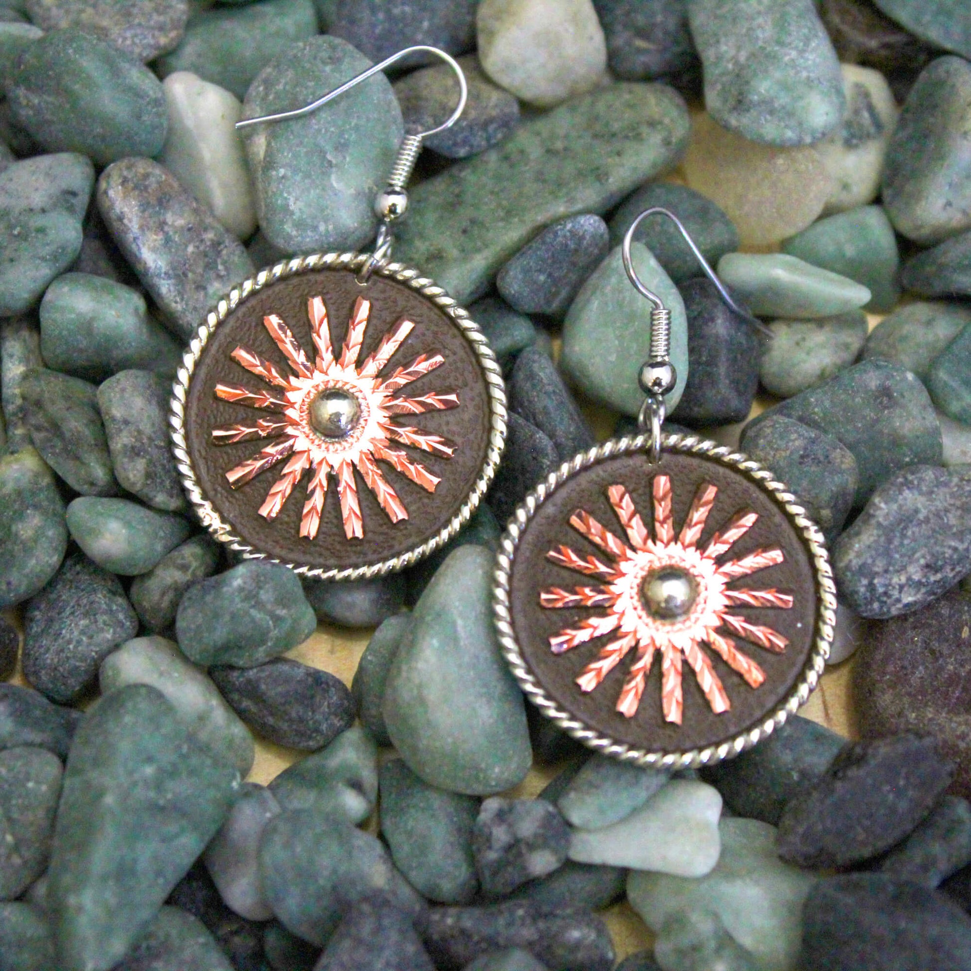 Saddle up your style with the Western Rowel Earring. Crafted with a rope-edged round design and a striking copper rowel centerpiece, these earrings bring an unmistakable western vibe to your look. Approx. 1" diameter.