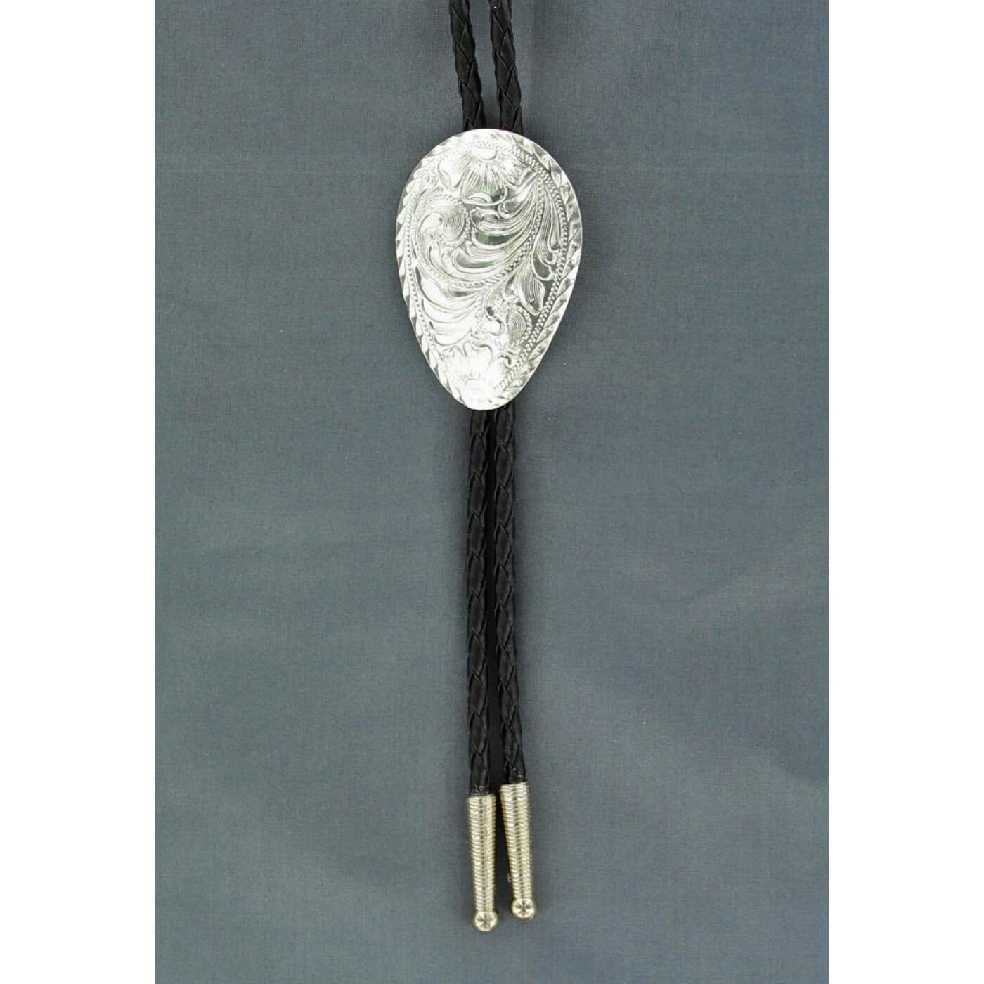 Add some flair to your western wear! Bolo tie features a black braided rope with silver tips accented with a shiny silver oval western floral engraved Concho. Adult bolo-36" long. Sterling Silver Plated. 