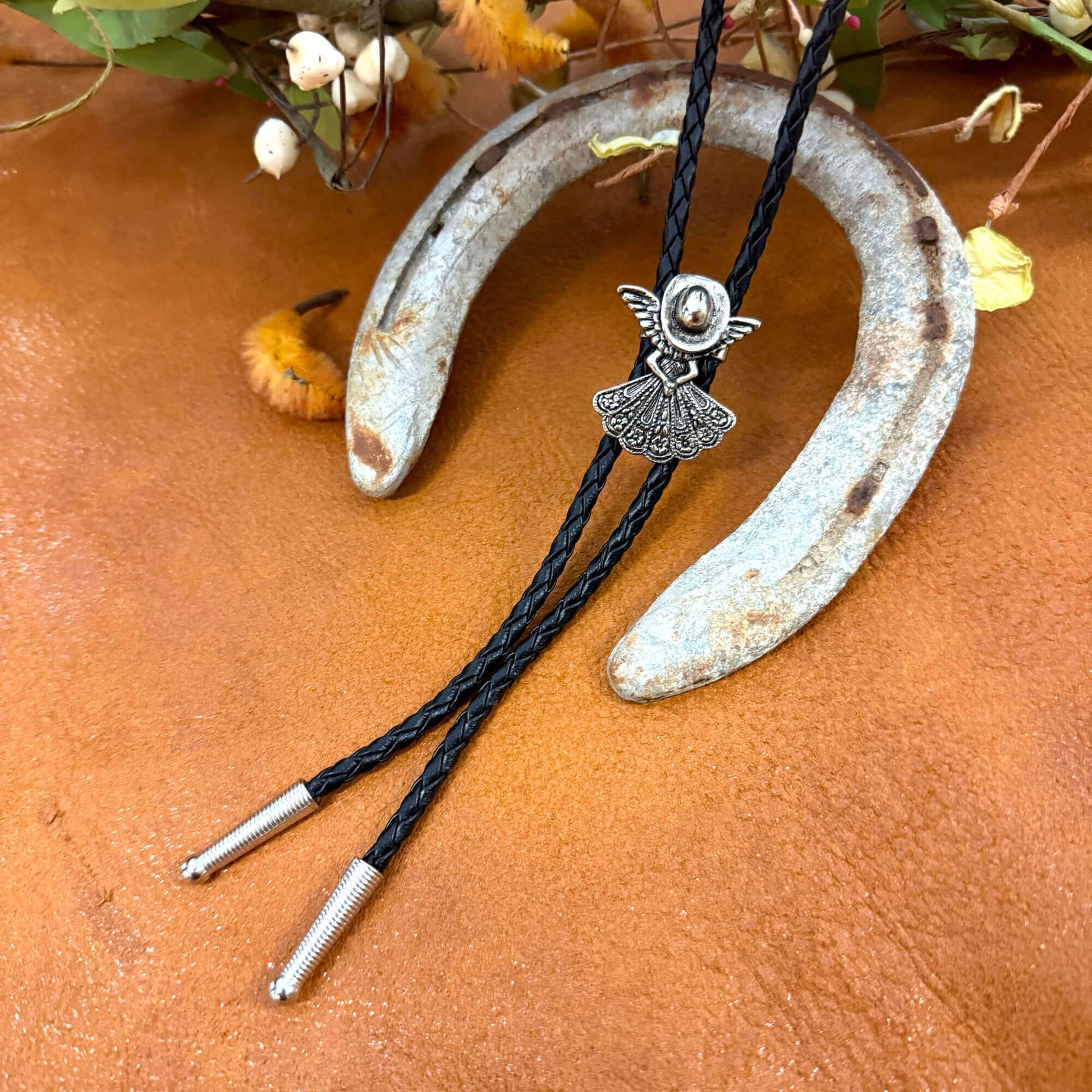 Bolo tie with decorative clasp on a rustic background
