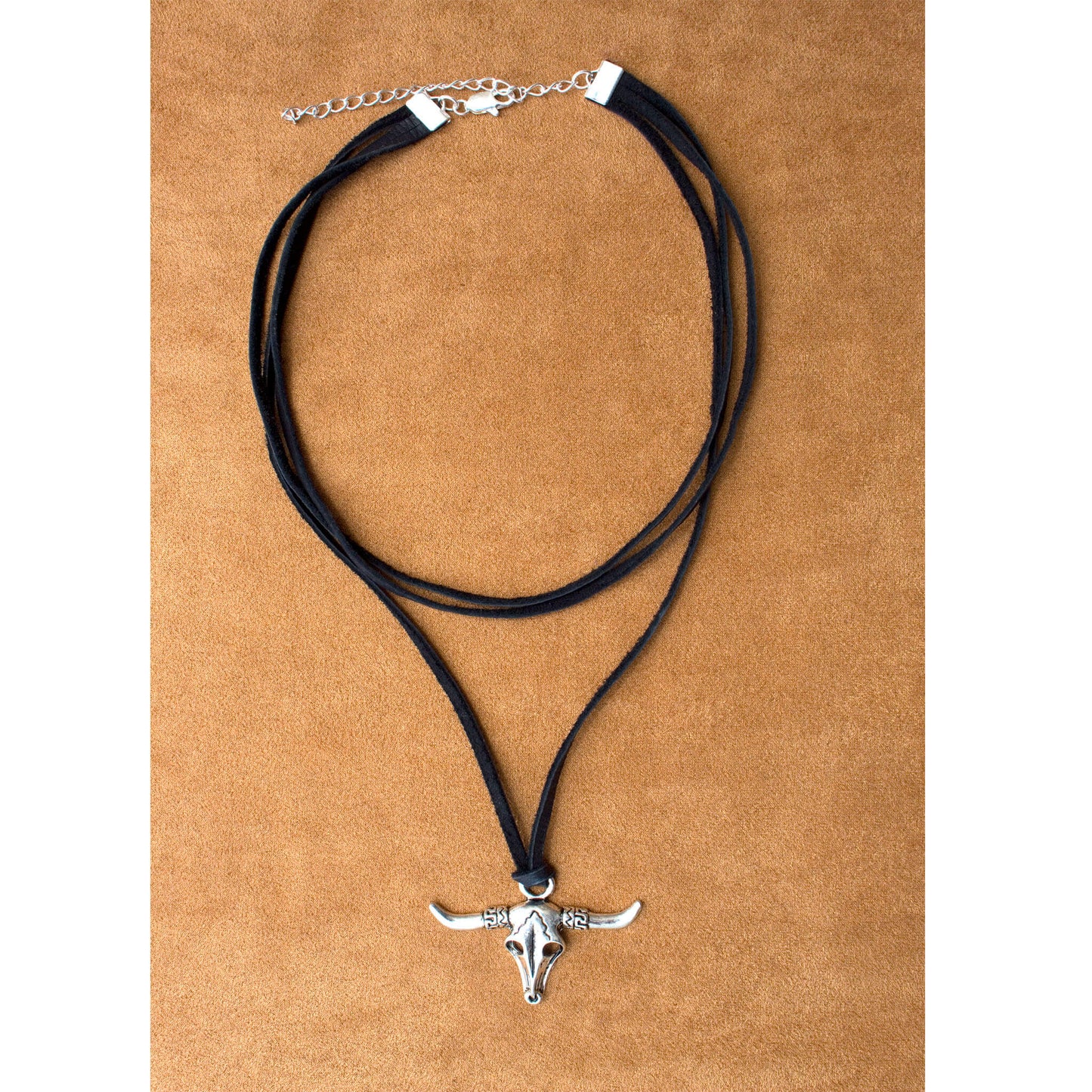 Add the perfect western flare to your look with this leather & skull cowgirl necklace. Three layers of black deer suede lace feature a silver skull pendant. Measures 16” long with 3” extender. Handcrafted in the USA.