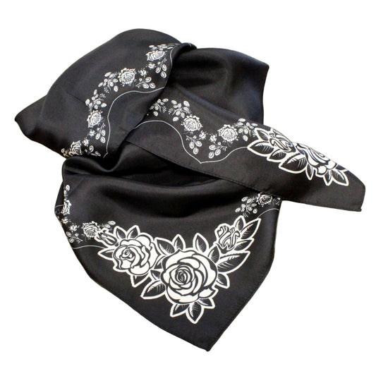 Black scarf with white floral embroidery on a brown cardboard background