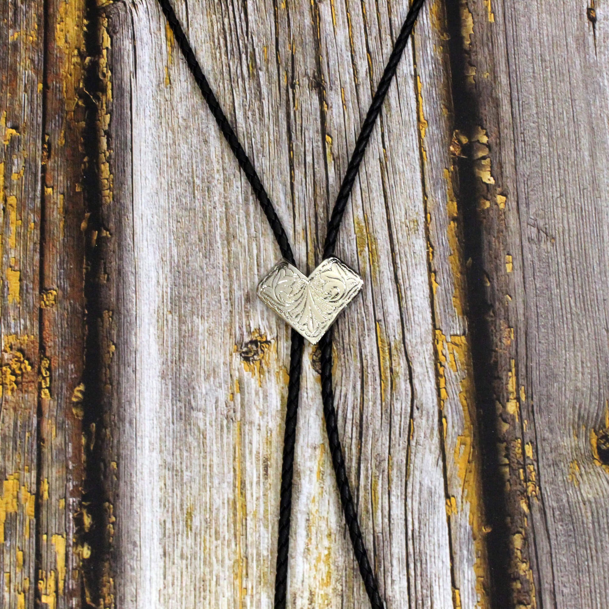 Bolo Tie with a V-shaped pendant on a wooden surface