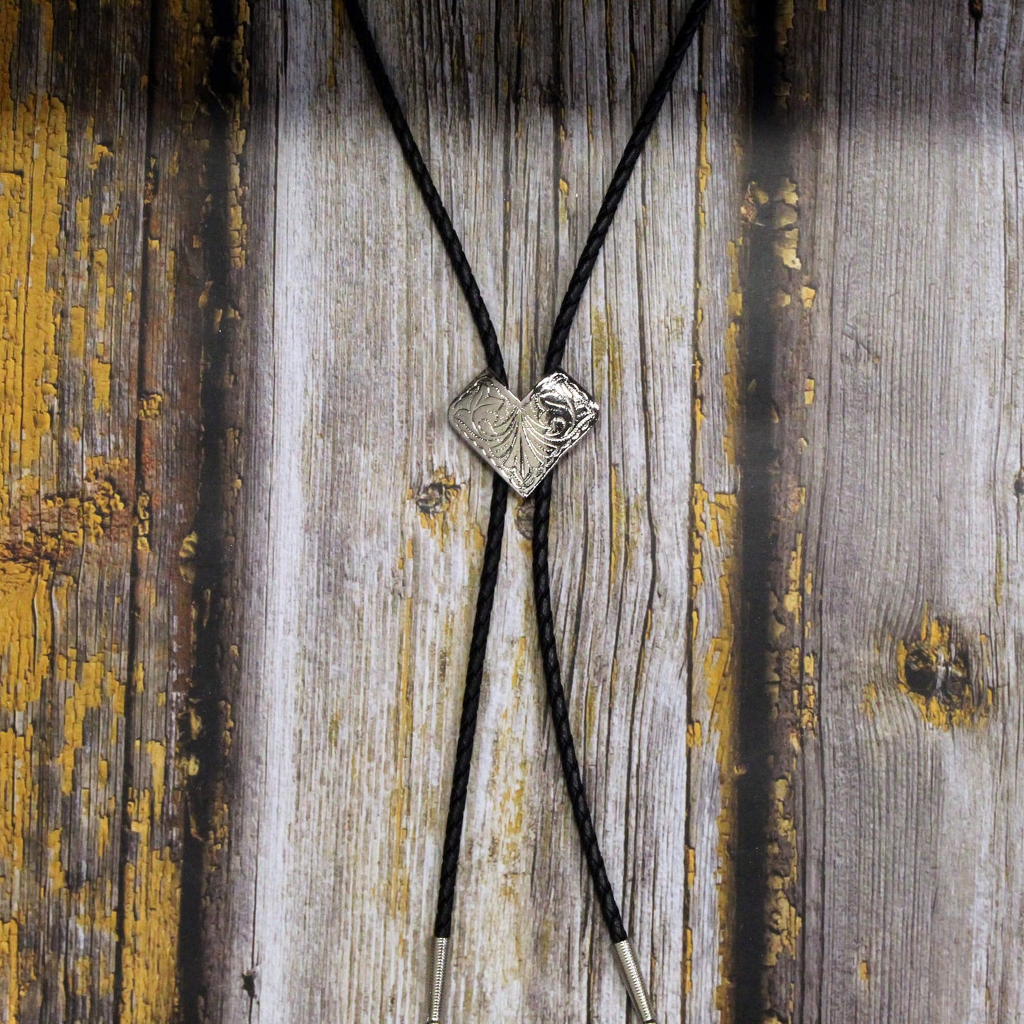 Bolo tie with a silver clasp on a wooden background