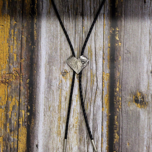 Bolo tie with a silver clasp on a wooden background