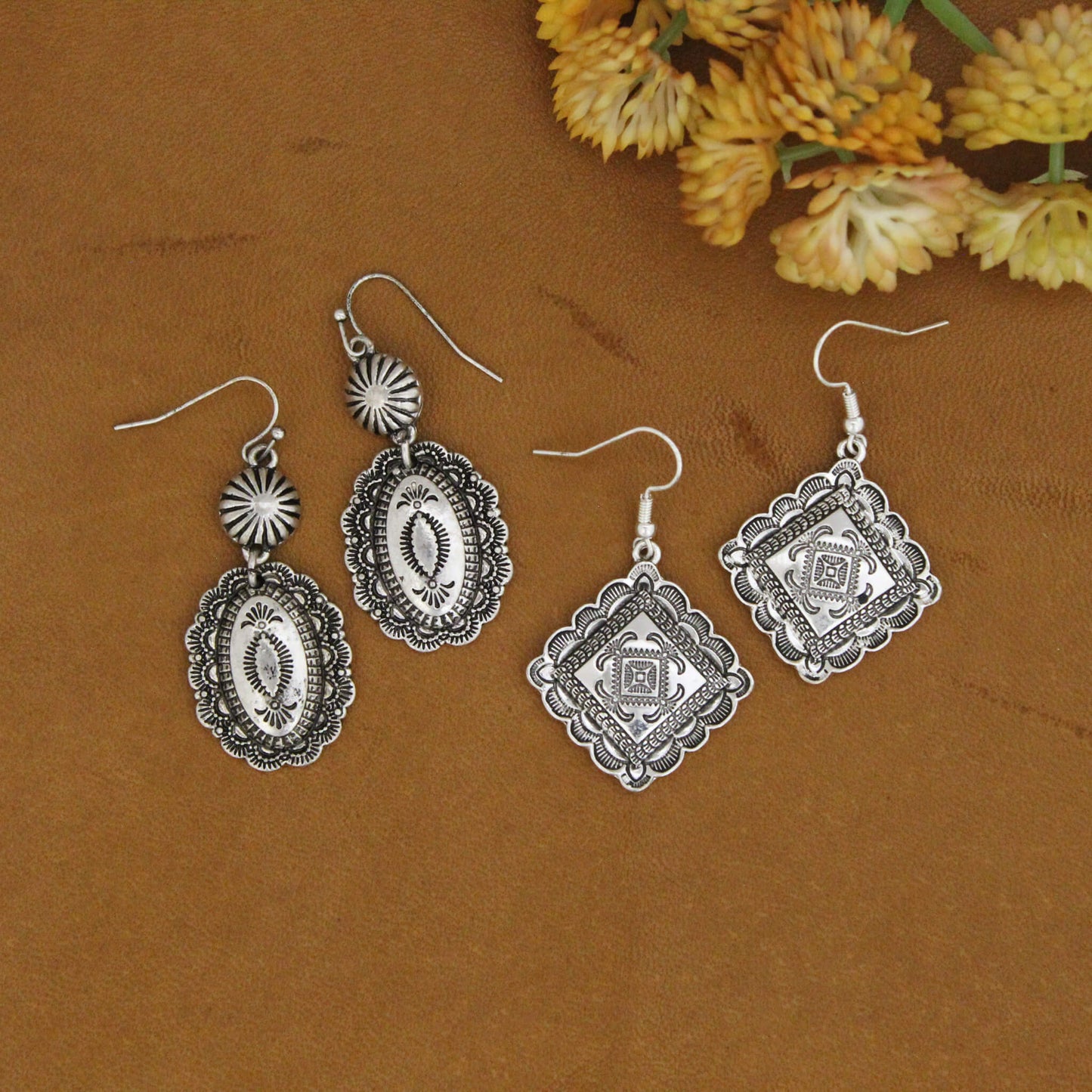 Cool effortless cowgirl silver etched Southwest earrings. These cowgirl earrings are the perfect go-to earrings. Antique silver in a unique design on diamond shaped earrings or oval dangle. Antique silver hypo-allergenic ear wires. Dangle pair measure about 2" long and 7/8" wide oval Concho. Diamond shape measure 1" by 1"