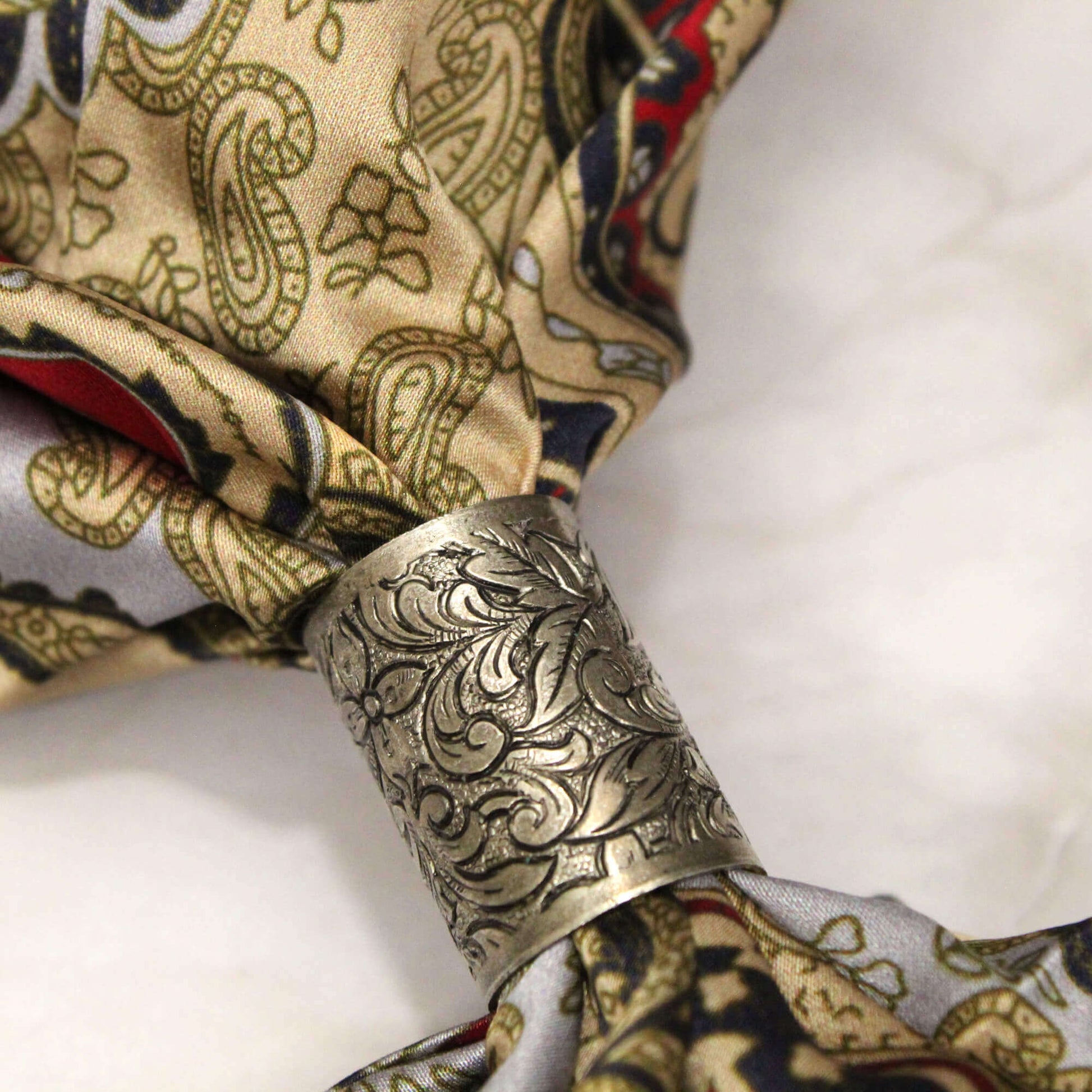 Here is a lovely scarf slide that will hold your neck garment in place and add a special fancy touch to your western cowboy scarves. If you need something to hold a scarf in place without having to knot it up, this simple tube style scarf slide will do the trick. Measures 1" long with .5" diameter.