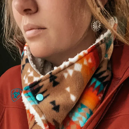 A woman wearing a colorful Fleece Cowboy Cowl neck warmer for warmth and style during winter.