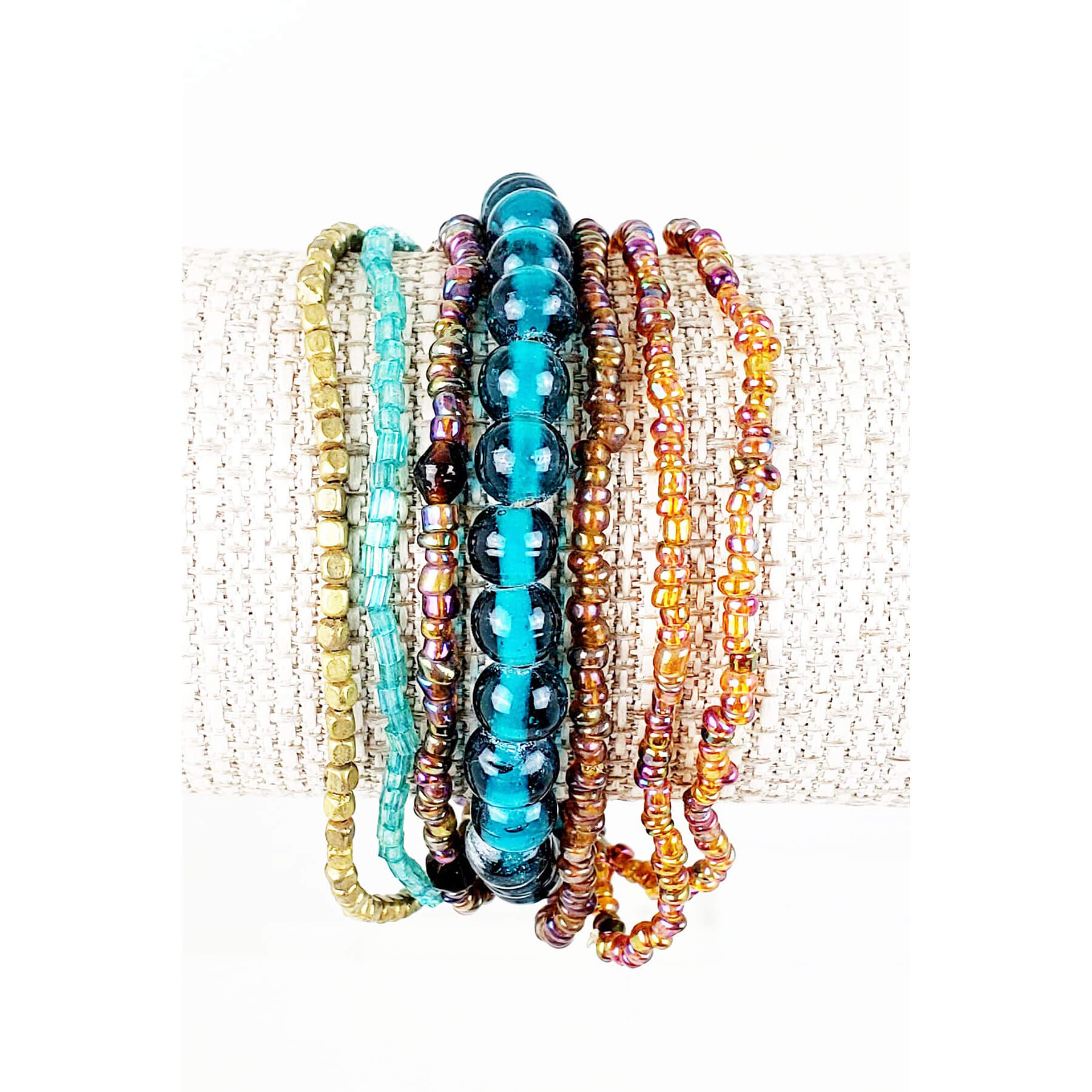 Cute beaded stretch bracelets that you can wearer everyday. Bands of brown, orange, teal and glass tied together with a strand of orange. One size fits most. Made in USA.