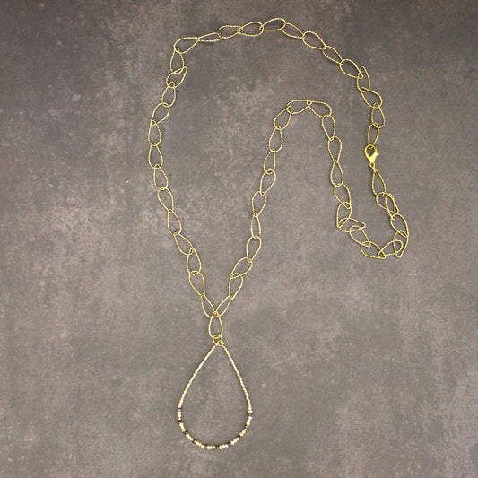 Gold chain necklace on a gray textured surface