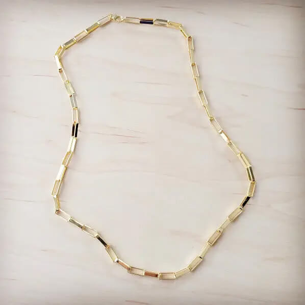 Gold necklace on a light wooden surface