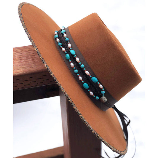 A classic that goes with any hat. Shimmering freshwater pearls, turquoise howlite and rust red seed beads are combined seven strand plait of Authentic Horse Hair. Finished with our sunburst Conchos, leather tassels and secured with a horse hair knot. Hat not included. One size fits most hats. Made in USA.