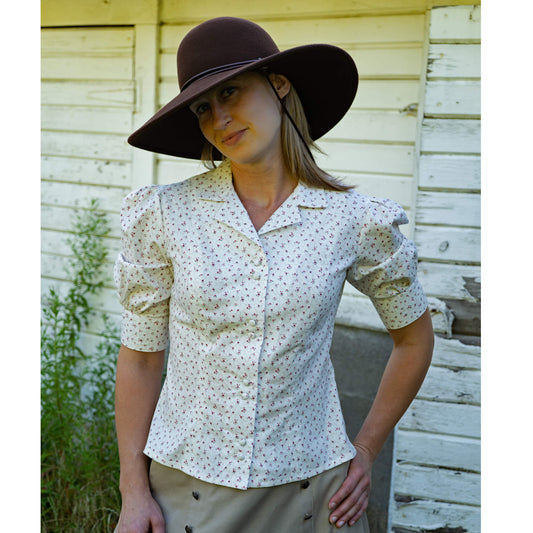 A country blouse that can take you from the farm to town with classic style. Princess seams give the blouse a flattering fit with proportional sleeves that hit right above the elbow with a wide cuff. Made in a soft 100% cotton print of tiny flowers in blue or pink.  Made in USA