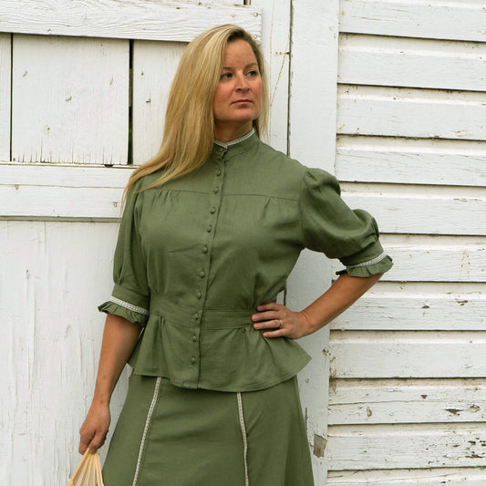 Our Homestead Blouse is comfortable and flattering. It comes in three colors that can worn alone or match up with our Frontier Skirt. A 2-inch band at the waist gives it a feminine line and has elastic in the back for an easy fit. Tiny ruffles at the elbows and neck are detailed with delicate imported lace. Constructed of a Linen/Rayon blend. Made in USA