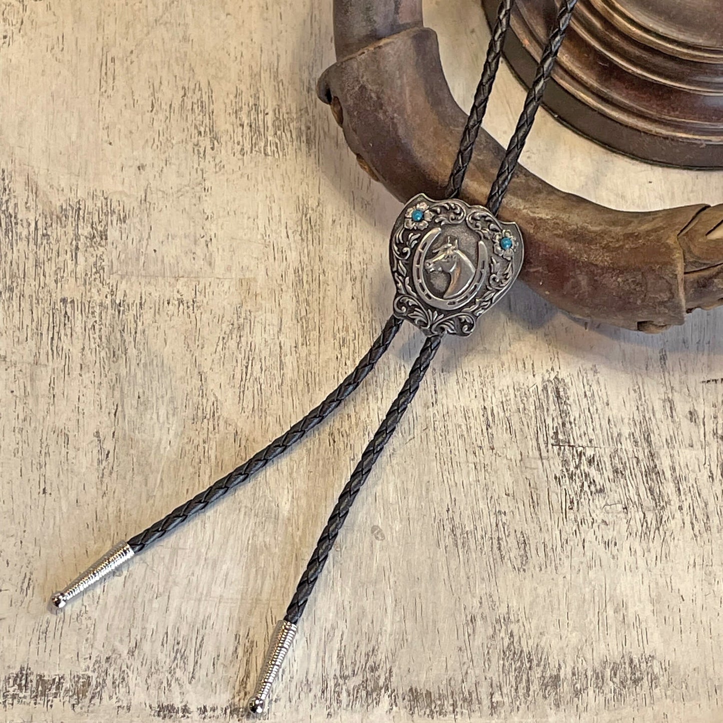 The simply elegant design of this horse head and horseshoe bolo tie transitions easily between casual and formal wear. This horsehead bolo tie, with its fancy detail, will give your outfits a sharp-looking western addition for an affordable price. 