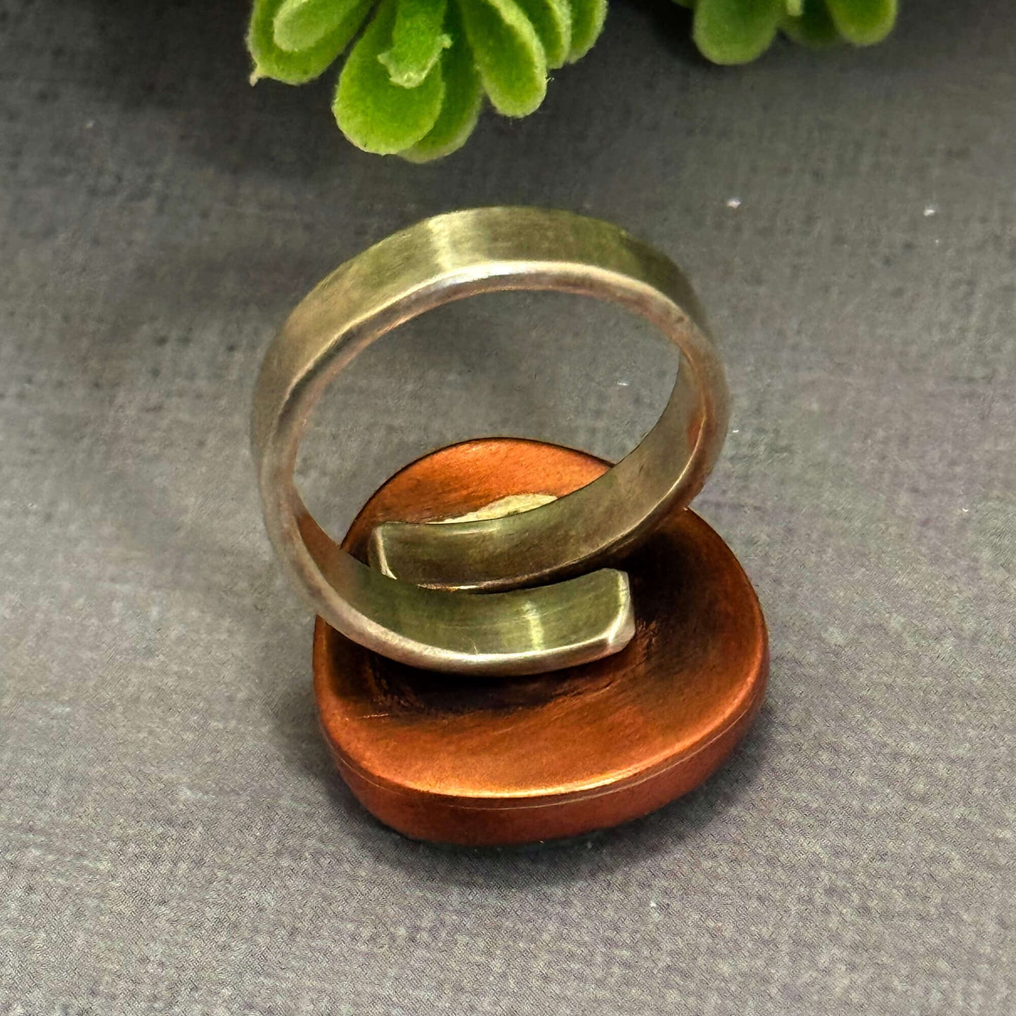 Handmade J Marie genuine turquoise ring on copper base, featuring a unique design and adjustable fit.