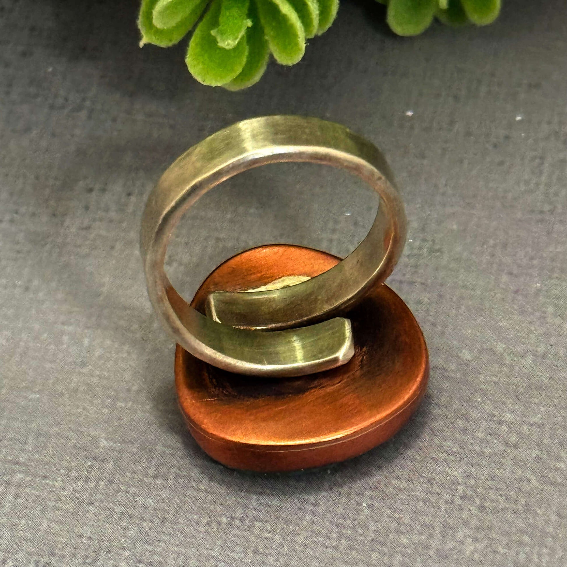 Handmade J Marie genuine turquoise ring on copper base, featuring a unique design and adjustable fit.