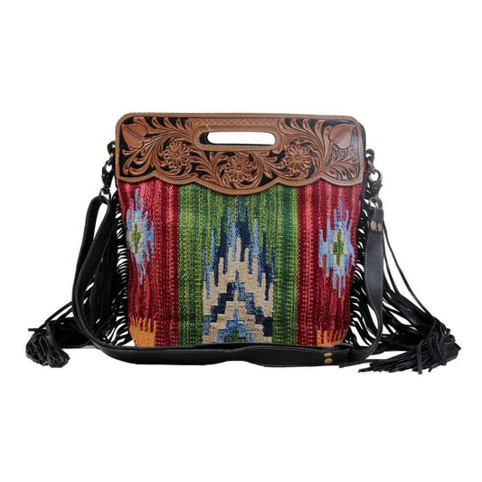 Upcycled from an attractive rug with vertical multicolored patterns and fringes on both sides make this a chic piece. It is perfect to carry all your essentials and has adjustable leather straps. 15.25x14x4.5 