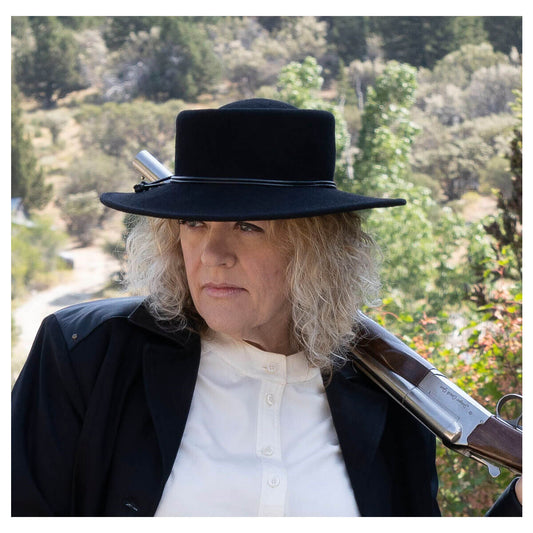 A classic shaped hat that boasts the days of the Frontier. Showcasing a narrow 3” brim and 3” telescoped Gambler crown with a gorgeous black leather cord wrapped around the brim and knotted on the side. Made for the rugged and tough lady of the West. Unlined wool-felt. This is a one size 22 ½” head size with an adjustable ribbon sweat band.