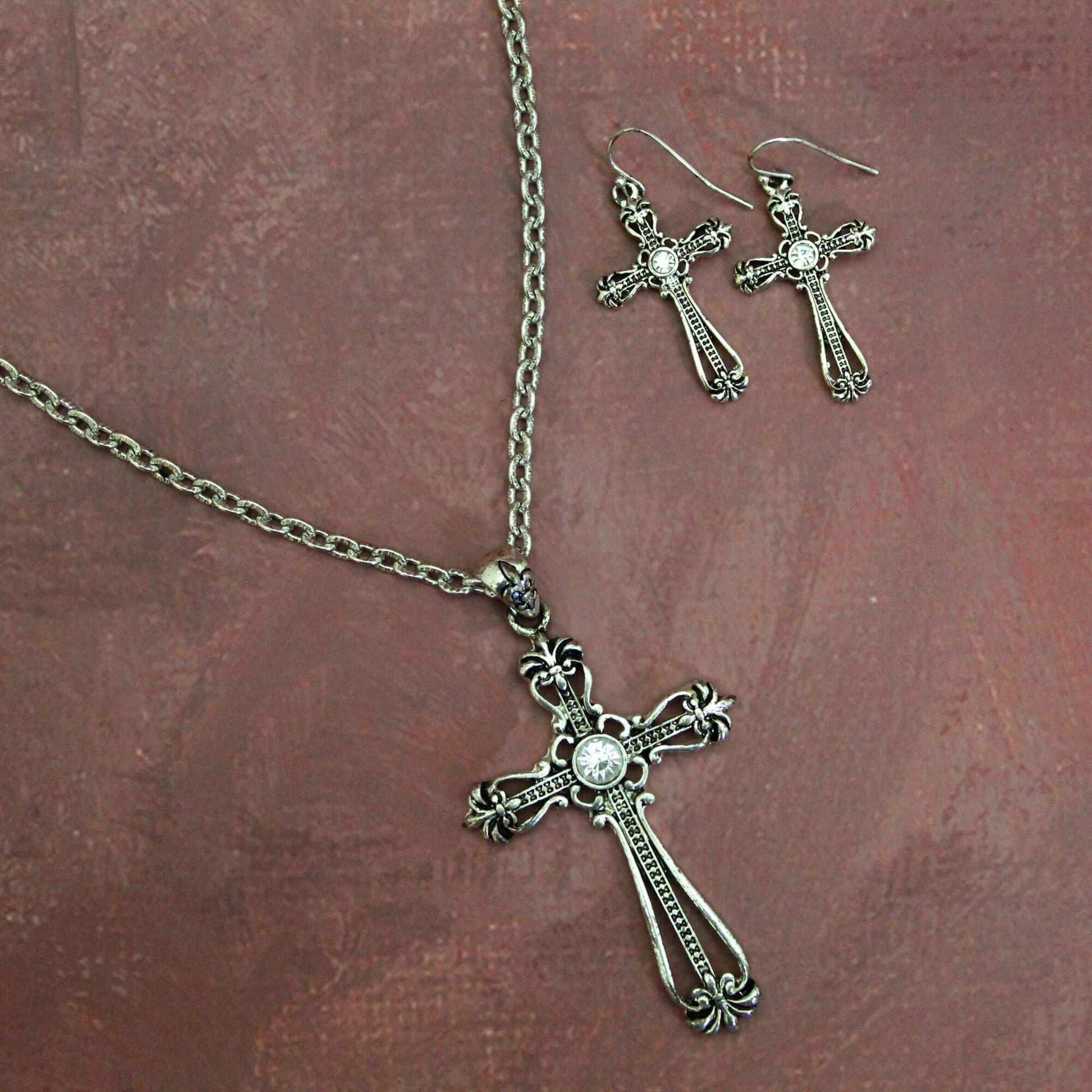 Show your beliefs in style with this charming cross necklace and earring set. The intricate detailing on the cross pendant makes this a sophisticated accessory, while the adjustable length chain allows you to wear it at just the right length for any neckline. Complete the look with the matching cross earrings that complement the pendant perfectly.