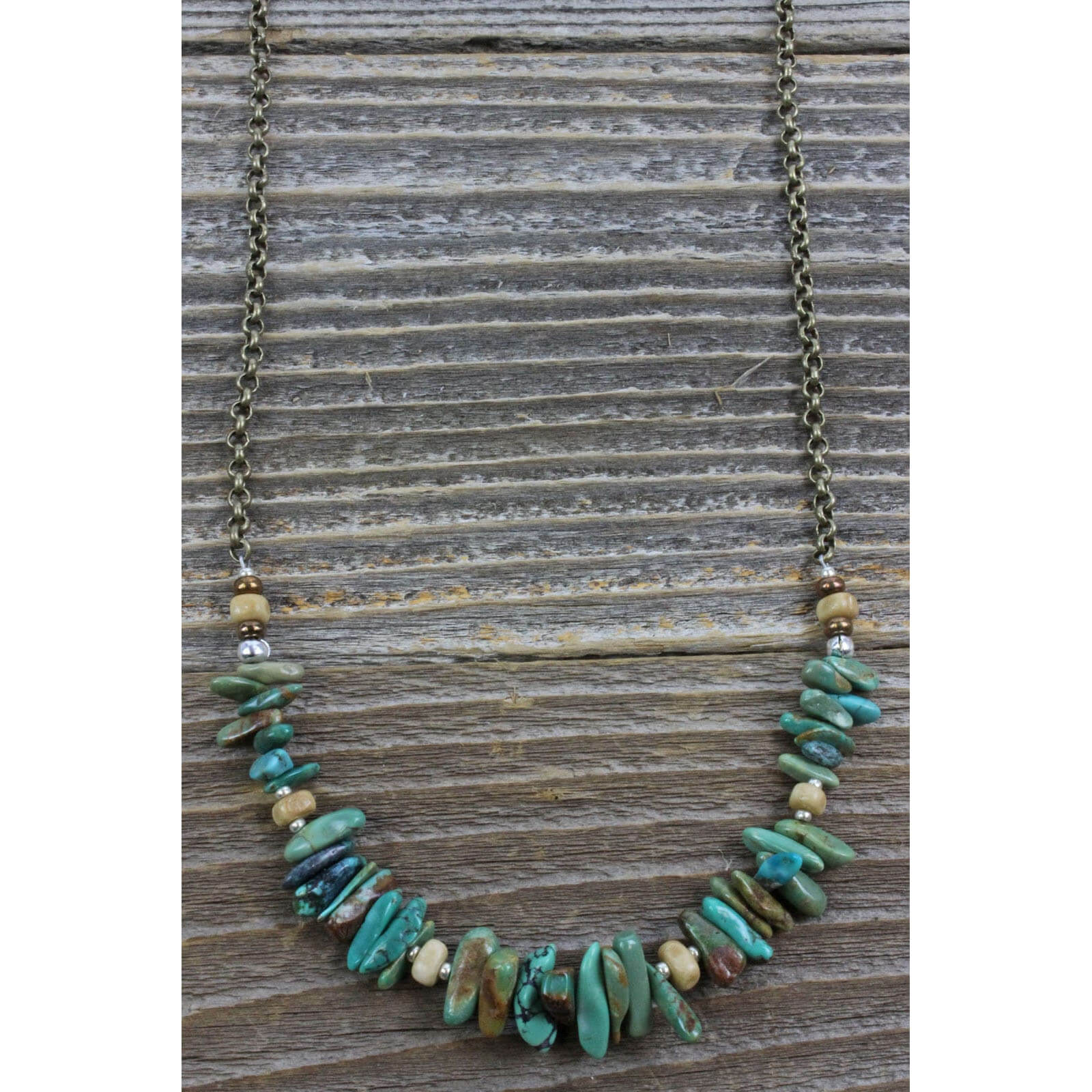 A single strand of stabilized Turquoise nuggets, bone and silver beads attached to a bronze chain. This teal gem promotes self-realization and assists creative problem solving. Measures 26″ including a 4″ extender and lobster claw clasp. Each piece is unique and may vary slightly. Made in USA