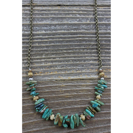 A single strand of stabilized Turquoise nuggets, bone and silver beads attached to a bronze chain. This teal gem promotes self-realization and assists creative problem solving. Measures 26″ including a 4″ extender and lobster claw clasp. Each piece is unique and may vary slightly. Made in USA