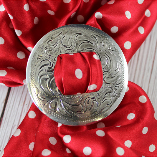 This engraved scarf slide is an eye catcher. Sterling silver plated. You pull your scarf through the double slot in the center of this wild rag slide. This slide will fit any scarves, wild rags, or bandannas. Country of origin Mexico. 2-1/2" diameter