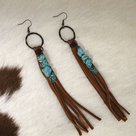 For the fashionista who likes to take risks, these earrings add artful flair to any outfit. The leather fringe gives off rugged cowgirl vibes, while the turquoise chunk beads lend a touch of artistic soul. Express your carefree attitude by accessorizing your look with these one-of-a-kind earrings. <span data-mce-fragment="1">Approx. Length: 5"</span>