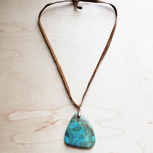 Genuine Leather Necklace is accented with a pendant of genuine Natural Turquoise. Great for layering or as a statement piece. The entire length of necklace is 24 inches Self-tie closure can be adjusted as needed. Pendant will vary in size from 1"-2" Although your item will resemble the photo, each piece is created by hand, so no two are identical. Made in USA