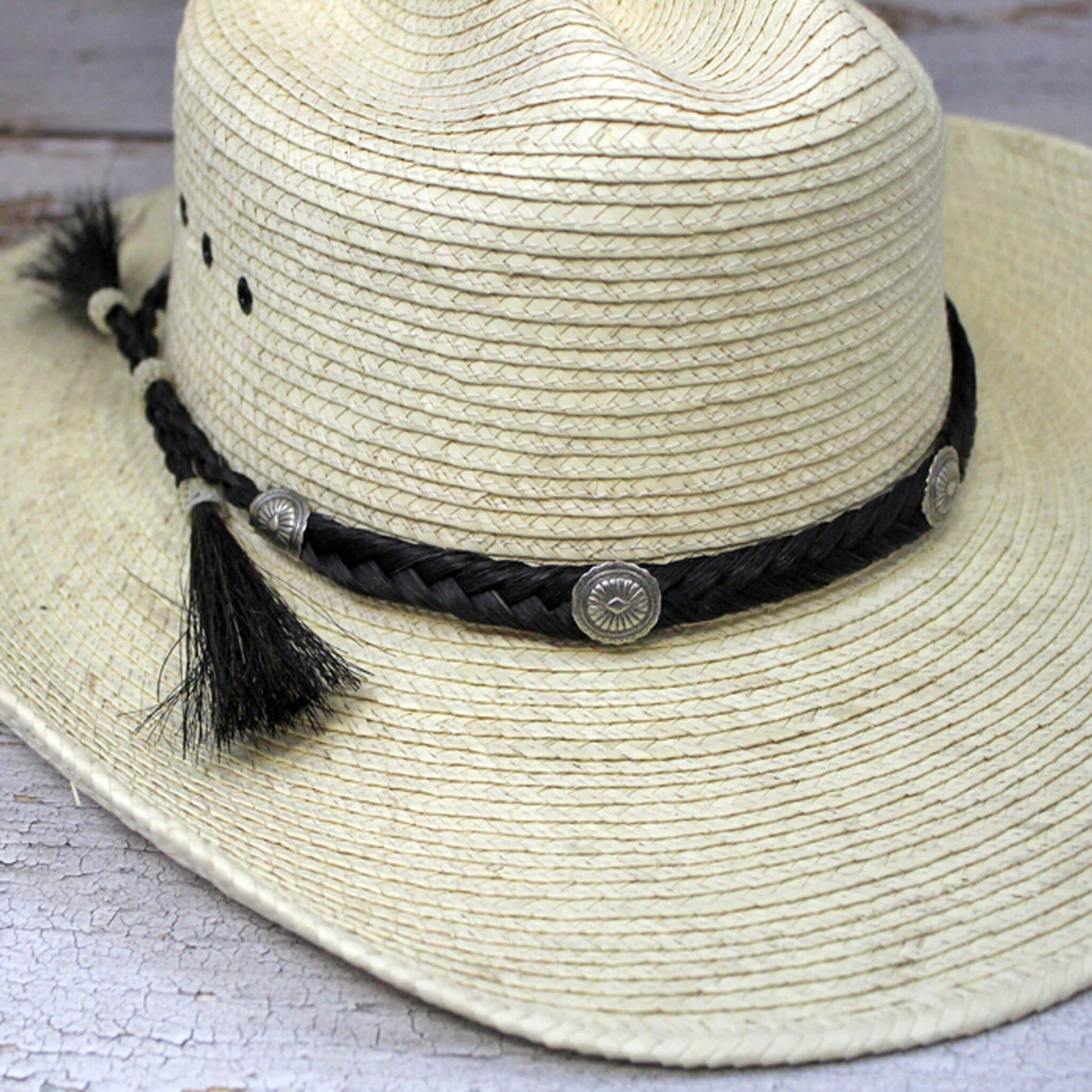 You ain't no cowboy unless you have an authentic horse hair hatband. Southwest sunburst conchos adorn the 1/2 inch wide braid of horse hair. Finished with hitched horse hair knots and tassels, this classic hatband is fully adjustable to fit any hat. Come in Black or Brown. Made in USA