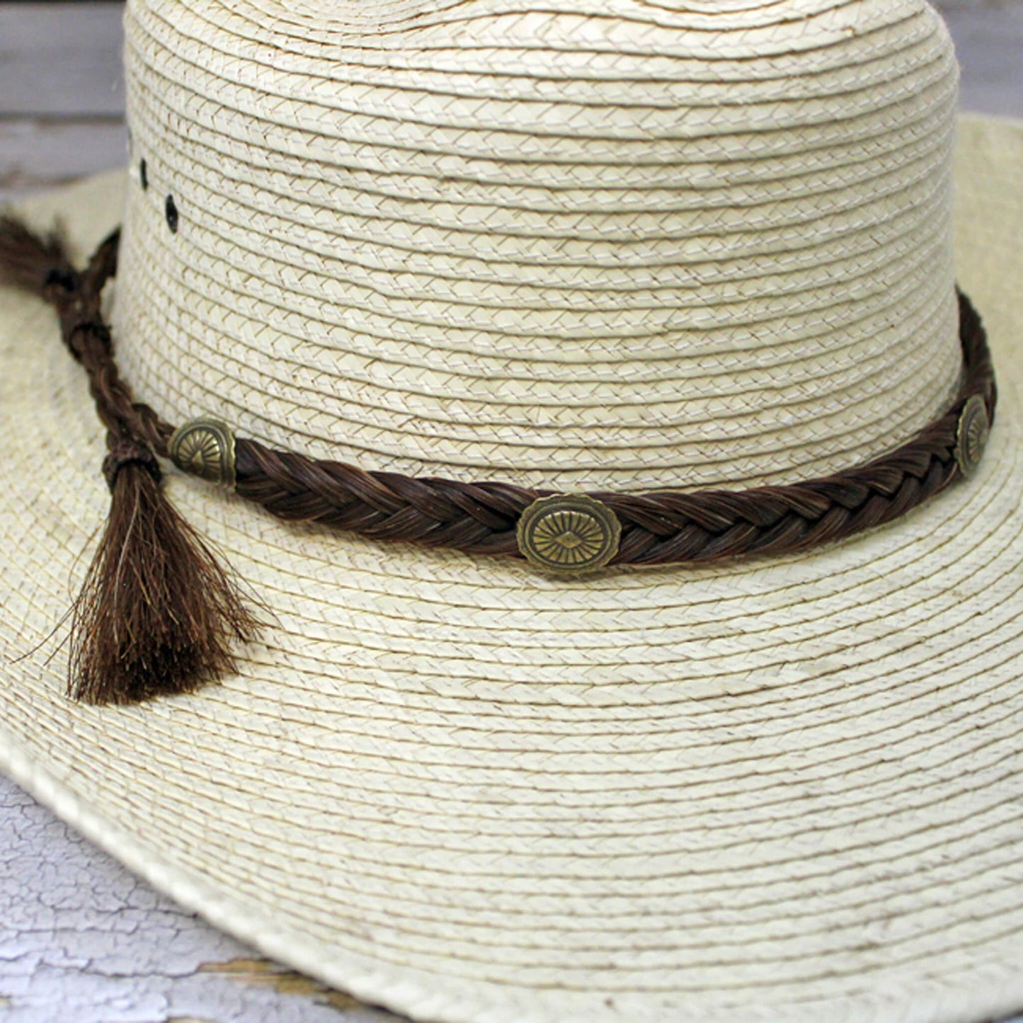 You ain't no cowboy unless you have an authentic horse hair hatband. Southwest sunburst conchos adorn the 1/2 inch wide braid of horse hair. Finished with hitched horse hair knots and tassels, this classic hatband is fully adjustable to fit any hat. Come in Black or Brown. Made in USA